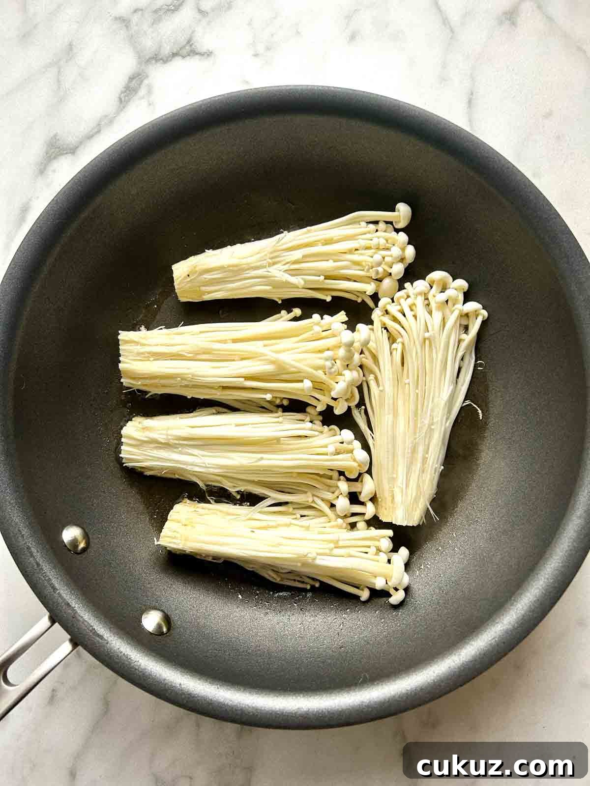 searing first side of enoki mushrooms