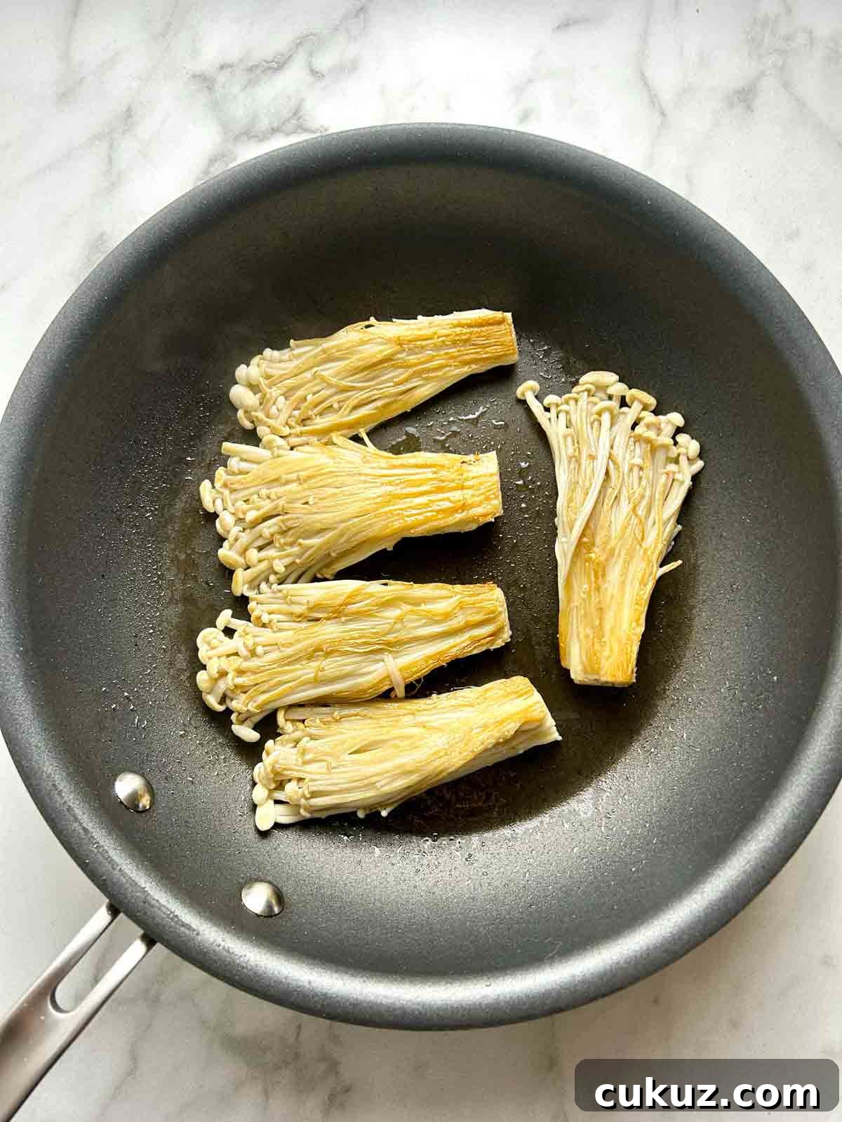 searing second side of enoki mushrooms