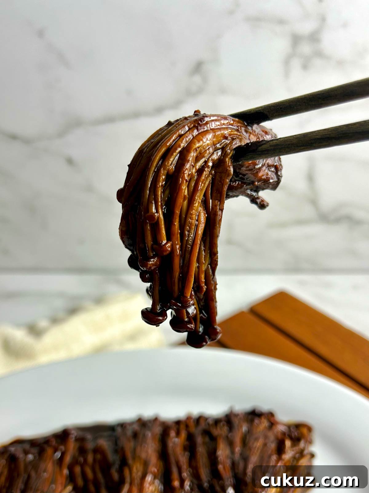 chopsticks holding enoki mushroom
