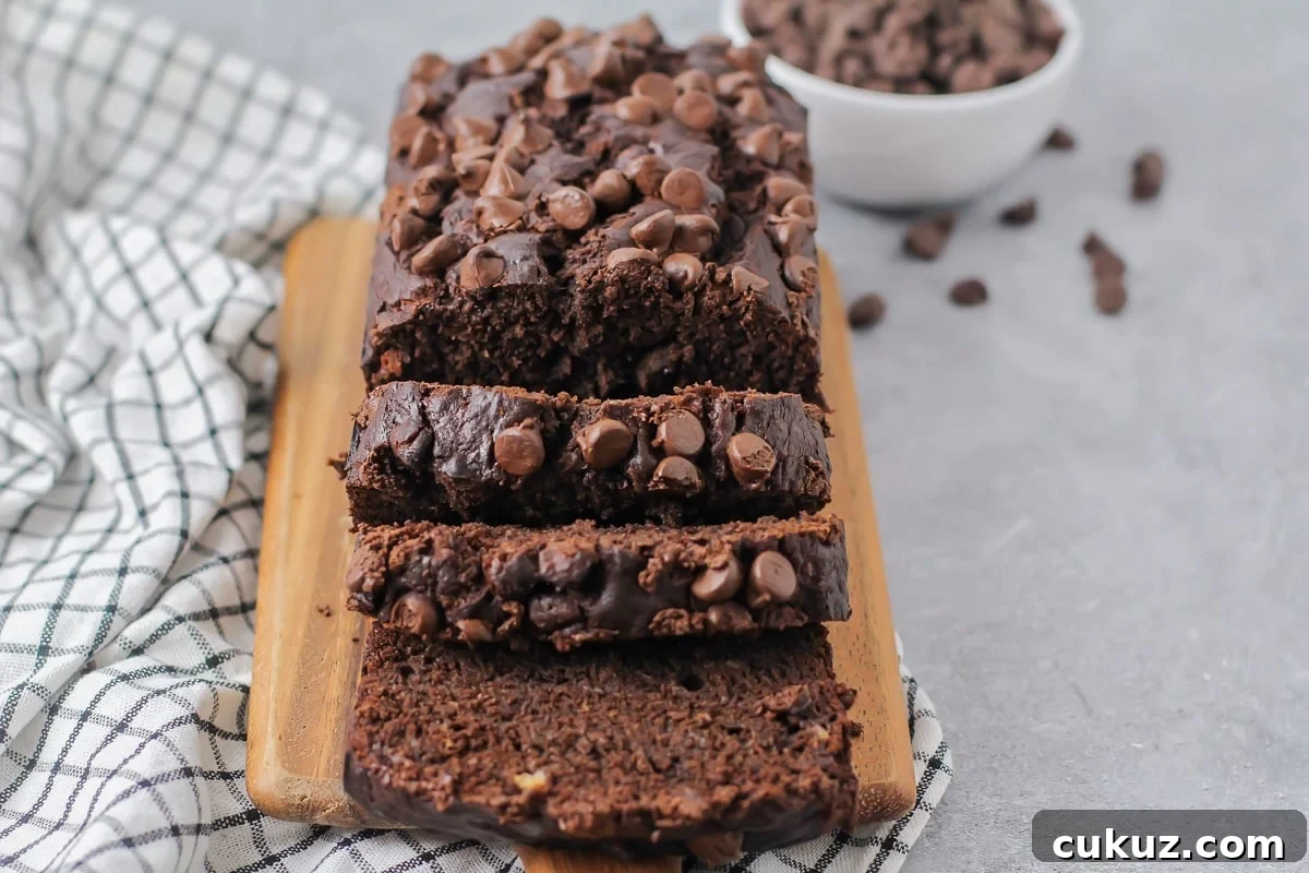 Chocolate banana bread sliced on cutting board.