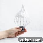 whisk attachment from a stand mixer with marshmallow filling on it