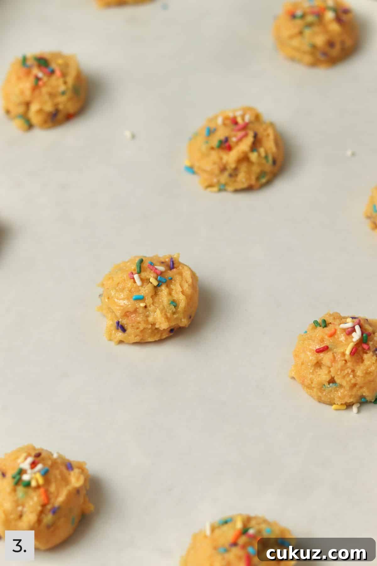 3-Ingredient Funfetti Cake Mix Cookies Recipe 6 Funfetti cake mix cookie dough balls on sheet pan with sprinkles on top.