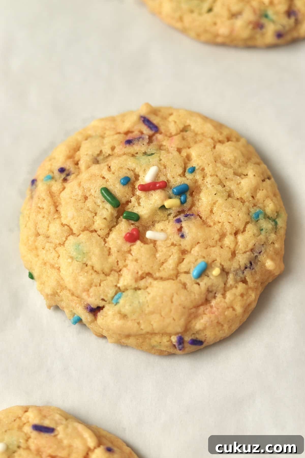 3-Ingredient Funfetti Cake Mix Cookies Recipe 8 close up of funfetti cake mix cookie on parchment paper.
