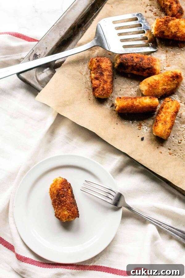 Oven baked potato croquette on a white plate. Ready to be served as a side dish.