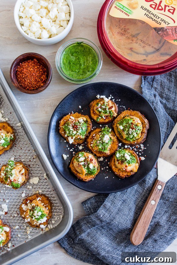 These pesto hummus sweet potato bites are the perfect bite size appetizer. Sumac roasted sweet potato rounds topped with spicy hummus, drizzled with spinach pesto and sprinkled with crumbled feta - how delicious is that! 