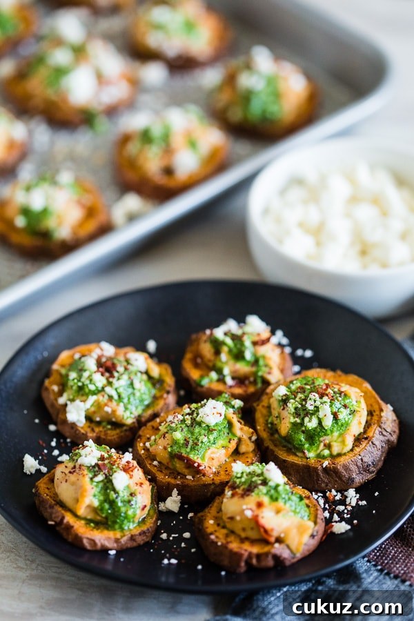 These pesto hummus sweet potato bites are the perfect bite size appetizer. Sumac roasted sweet potato rounds topped with spicy hummus, drizzled with spinach pesto and sprinkled with crumbled feta - how delicious is that! 