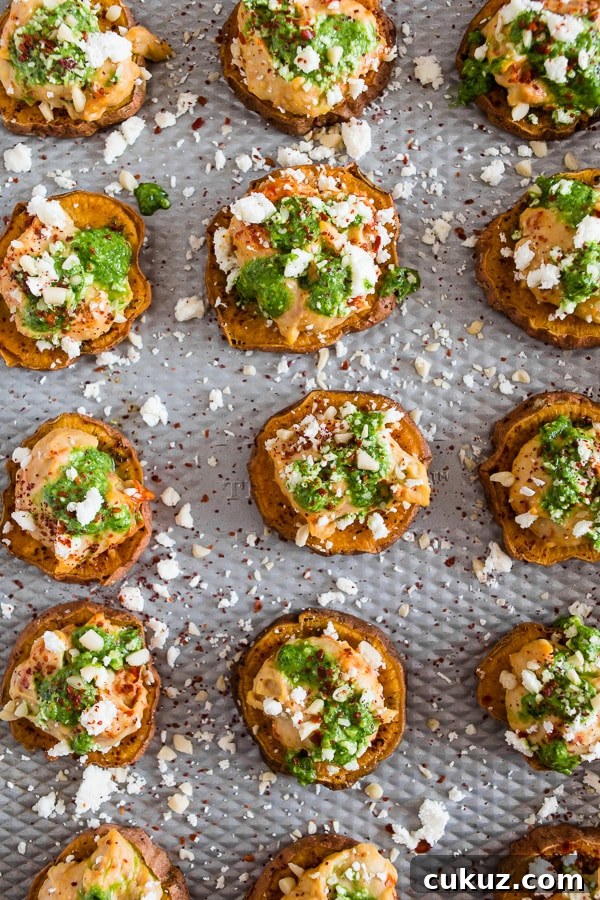 These pesto hummus sweet potato bites are the perfect bite size appetizer. Sumac roasted sweet potato rounds topped with spicy hummus, drizzled with spinach pesto and sprinkled with crumbled feta - how delicious is that! 