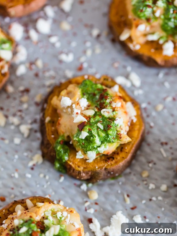 These pesto hummus sweet potato bites are the perfect bite size appetizer. Sumac roasted sweet potato rounds topped with spicy hummus, drizzled with spinach pesto and sprinkled with crumbled feta - how delicious is that! 