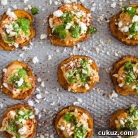 These pesto hummus sweet potato bites are the perfect bite size appetizer. Sumac roasted sweet potato rounds topped with spicy hummus, drizzled with spinach pesto and sprinkled with crumbled feta - how delicious is that!