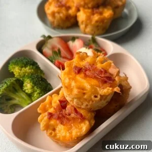 Cheesy Mac and Cheese Muffins: Savory Bite-Sized Comfort Food 8 Mac and cheese muffins served with strawberries and broccoli.