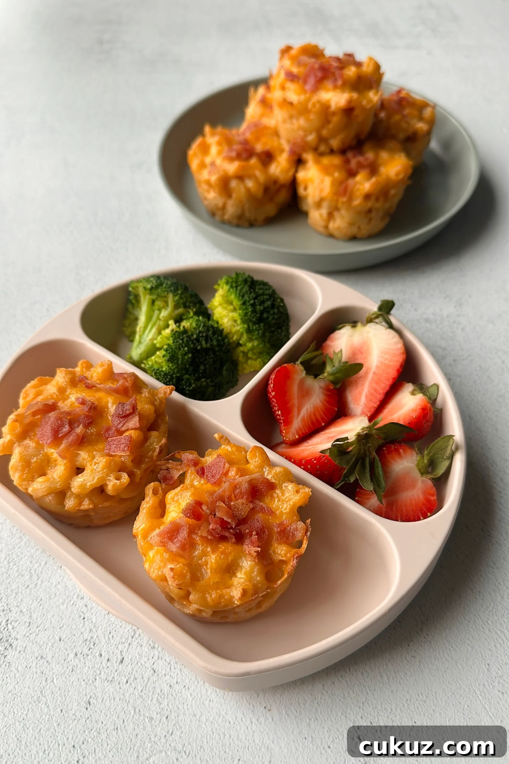 Cheesy Mac and Cheese Muffins: Savory Bite-Sized Comfort Food 6 Mac and cheese muffins served with strawberries and broccoli.