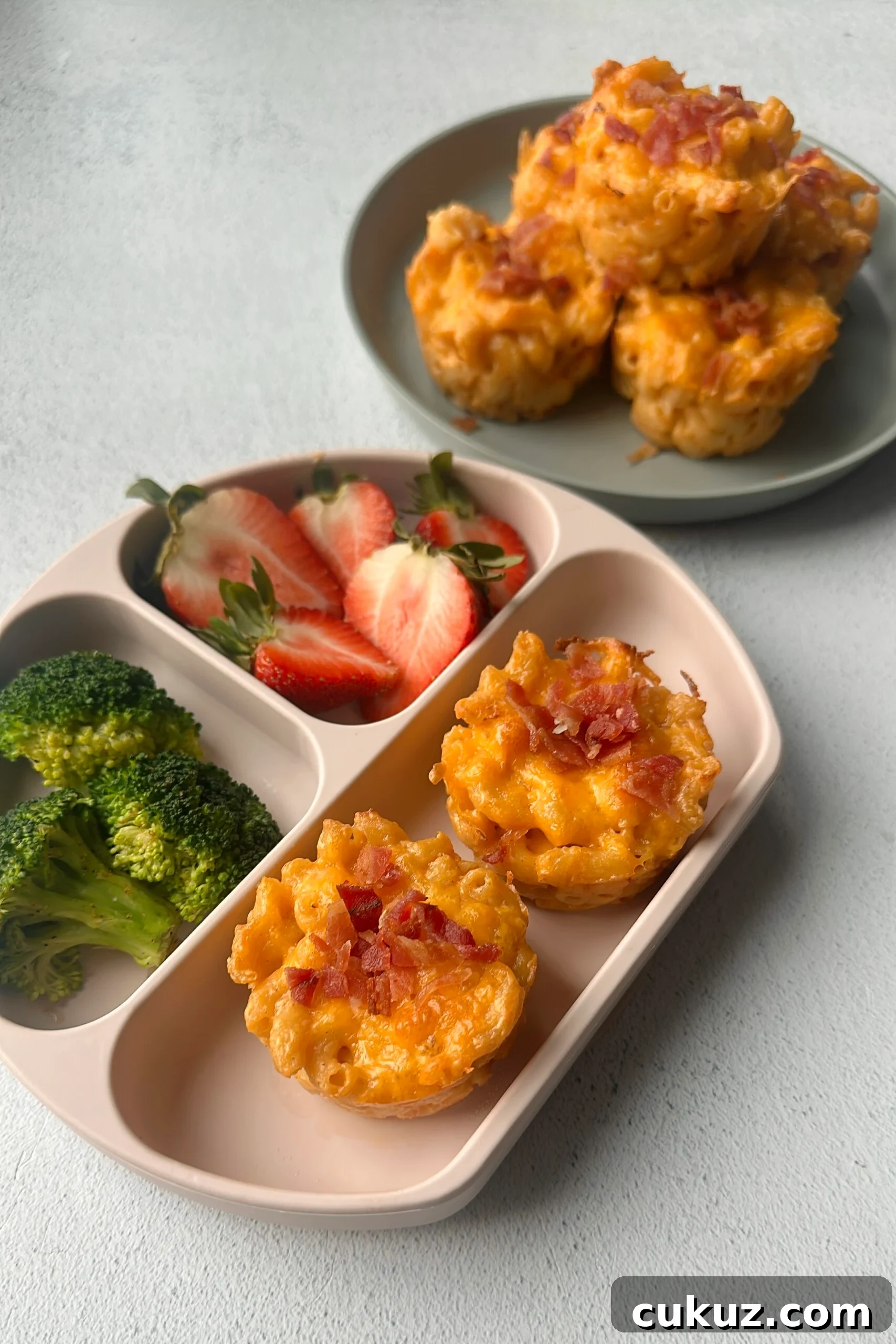 Cheesy Mac and Cheese Muffins: Savory Bite-Sized Comfort Food 7 Mac and cheese muffins served with strawberries and broccoli.