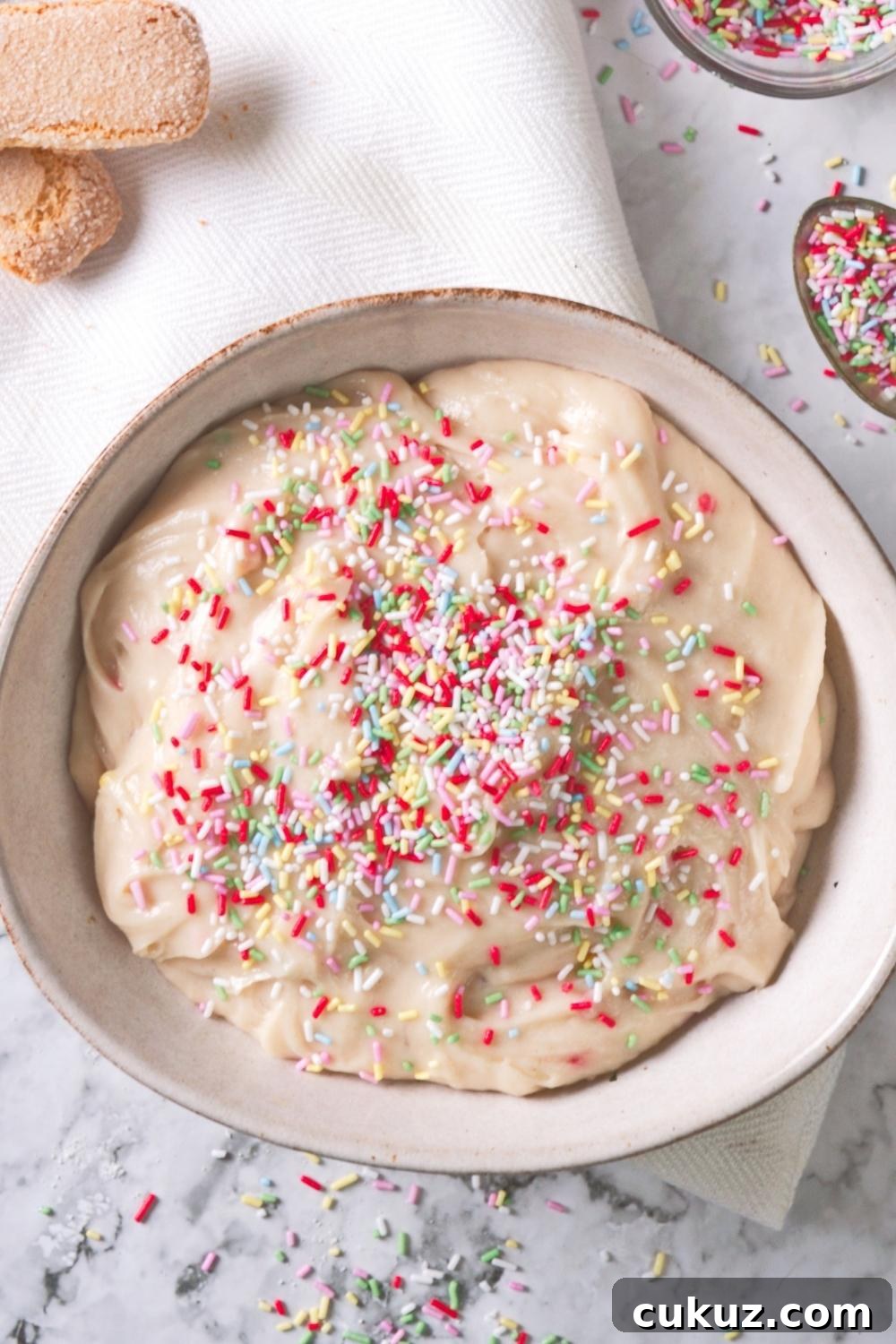 Quick 4-Ingredient Dunkaroo Dip Ready in 5 Minutes 2 An overhead view of a serving bowl containing homemade dunkaroo dip topped with rainbow sprinkles.