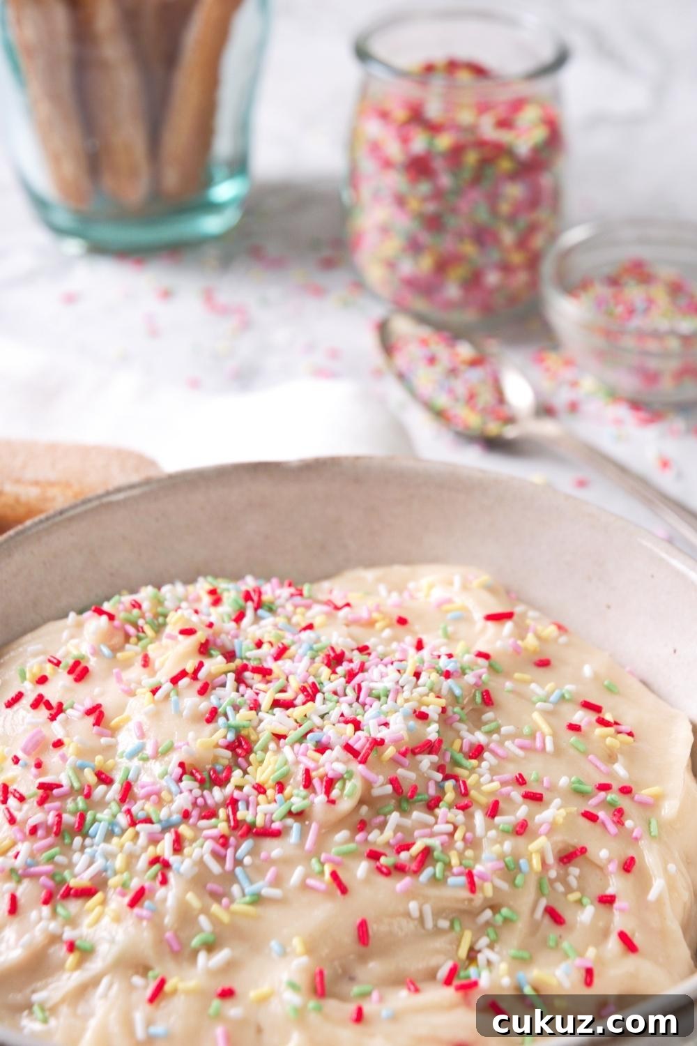 Quick 4-Ingredient Dunkaroo Dip Ready in 5 Minutes 11 An overhead close-up of a serving bowl containing homemade Dunkaroo dip topped with rainbow sprinkles.