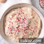 An overhead view of a serving bowl containing homemade dunkaroo dip topped with rainbow sprinkles.