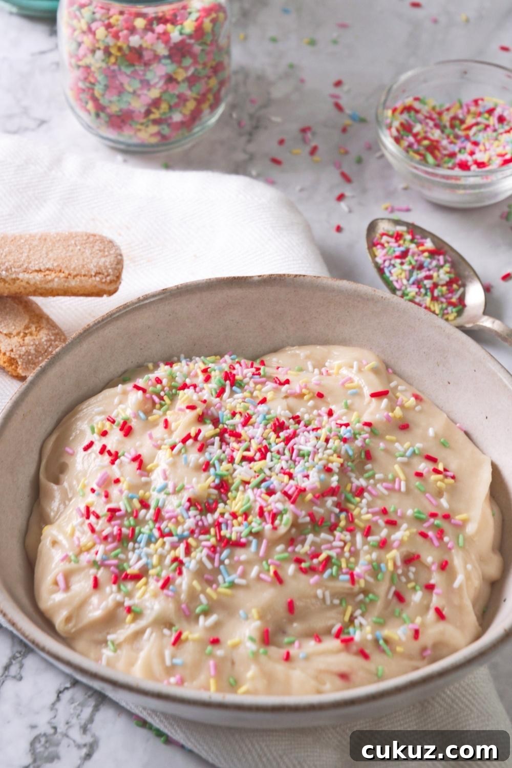 Quick 4-Ingredient Dunkaroo Dip Ready in 5 Minutes 3 An overhead view of a serving bowl containing homemade Dunkaroo dip topped with rainbow sprinkles.