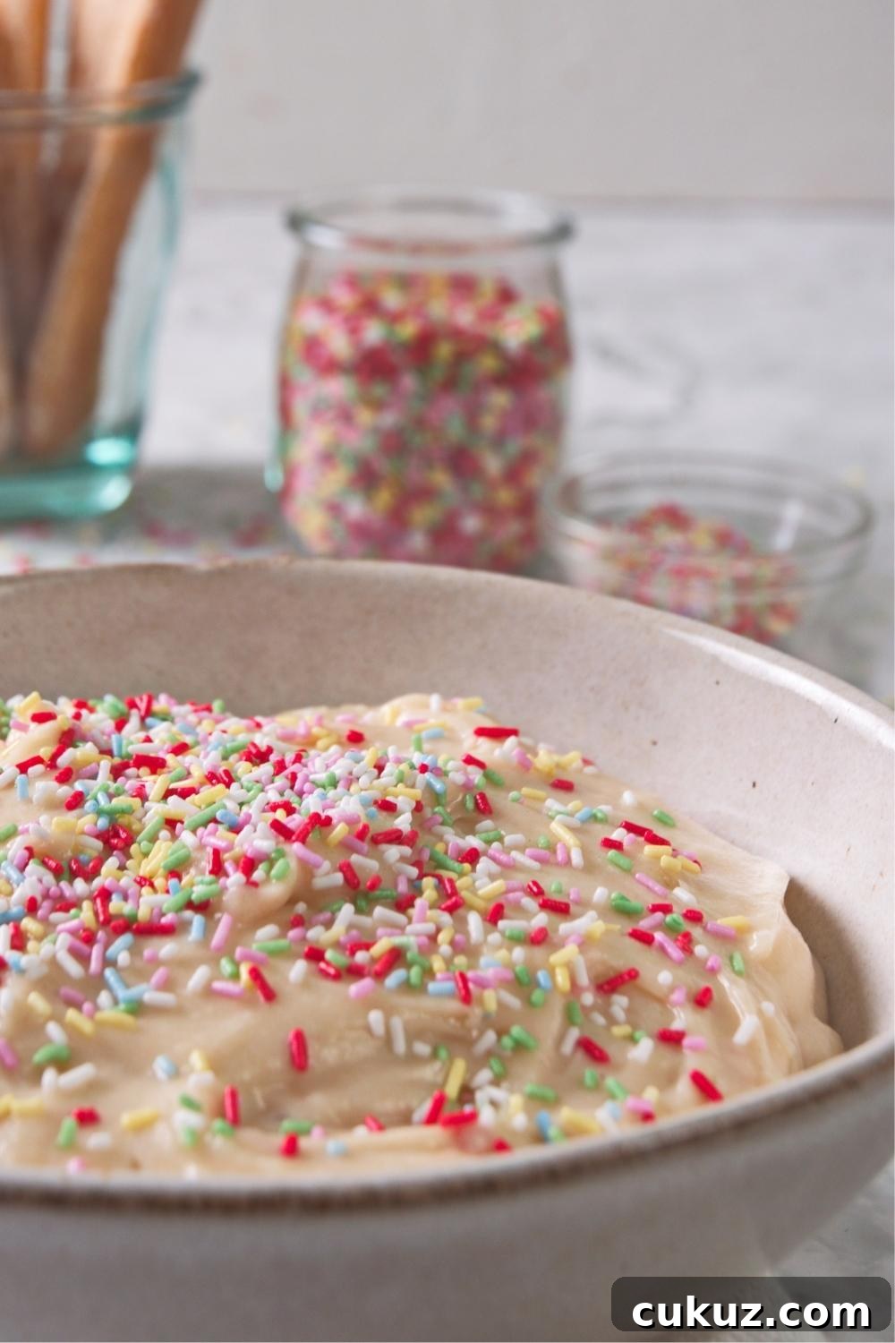 Quick 4-Ingredient Dunkaroo Dip Ready in 5 Minutes 7 A close-up of a serving bowl containing homemade dunkaroo dip topped with rainbow sprinkles.