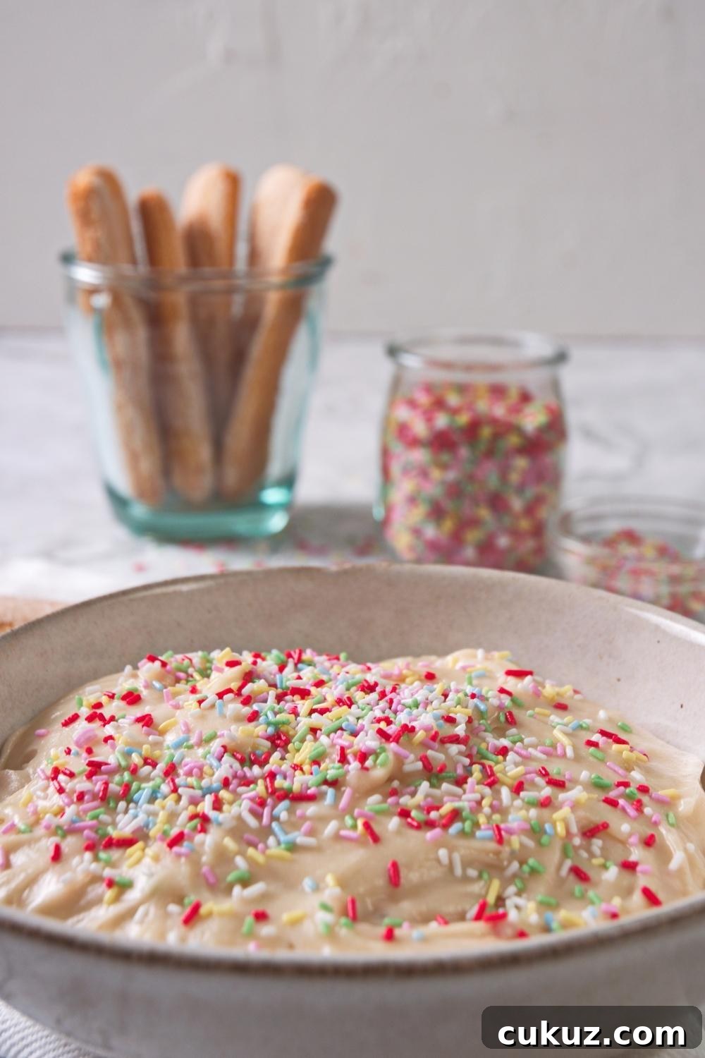 Quick 4-Ingredient Dunkaroo Dip Ready in 5 Minutes 8 A close-up of a serving bowl containing homemade Dunkaroo dip topped with rainbow sprinkles.