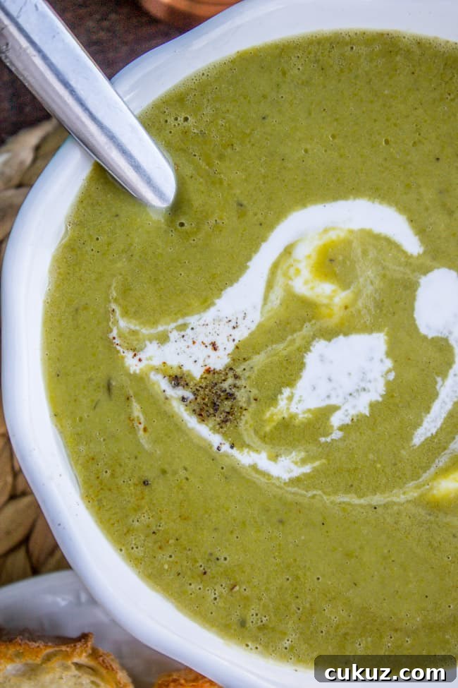 Creamy Frozen Pea Soup Ready in 30 Minutes 7 a bowl of homemade pea soup with cream and fresh pepper.