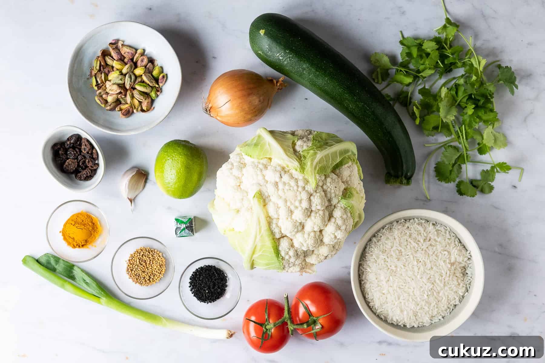 A shot of the ingredients needed to make spiced cauliflower and courgette with yellow rice.