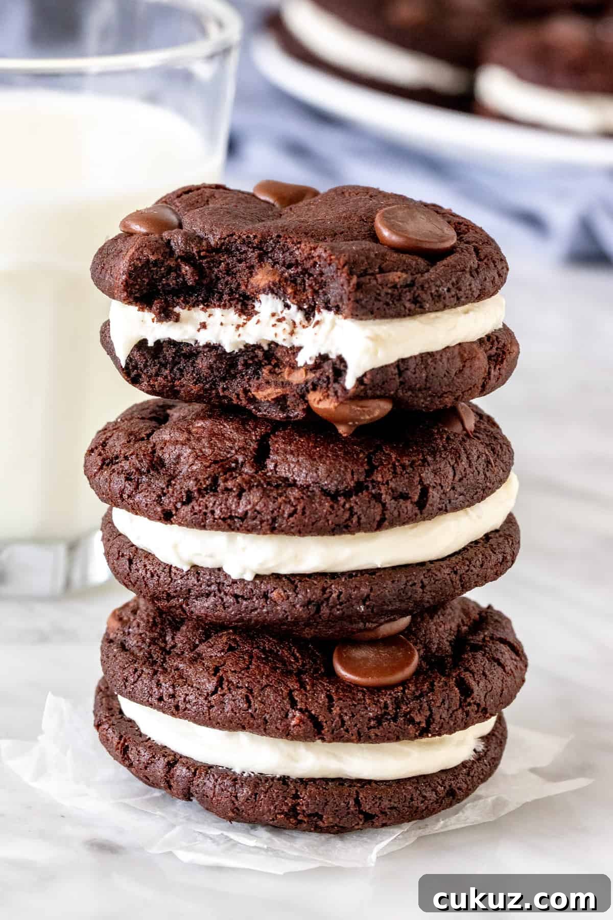 Stack of three chocolate cookies with vanilla frosting. 