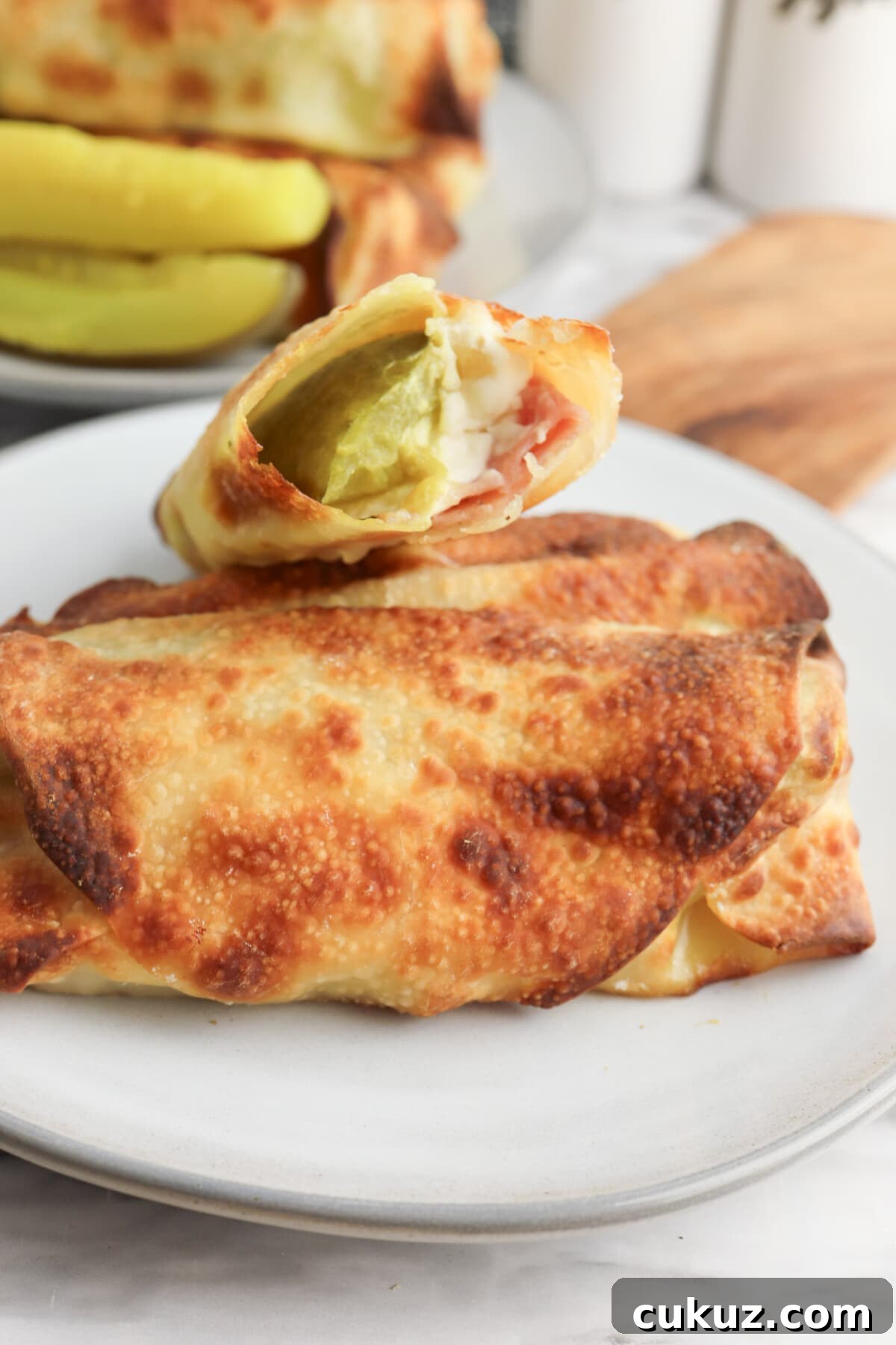 Try the delicious air fryer pickle egg rolls with ham and cream cheese pickle egg roll on a white plate