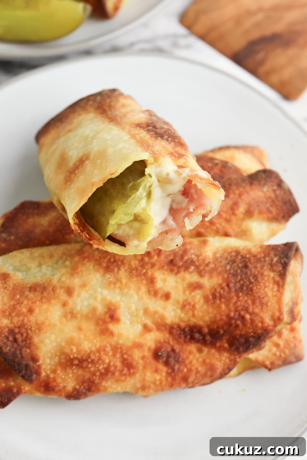 Try the delicious air fryer pickle egg rolls with ham and cream cheese pickle egg rolls on a white plate