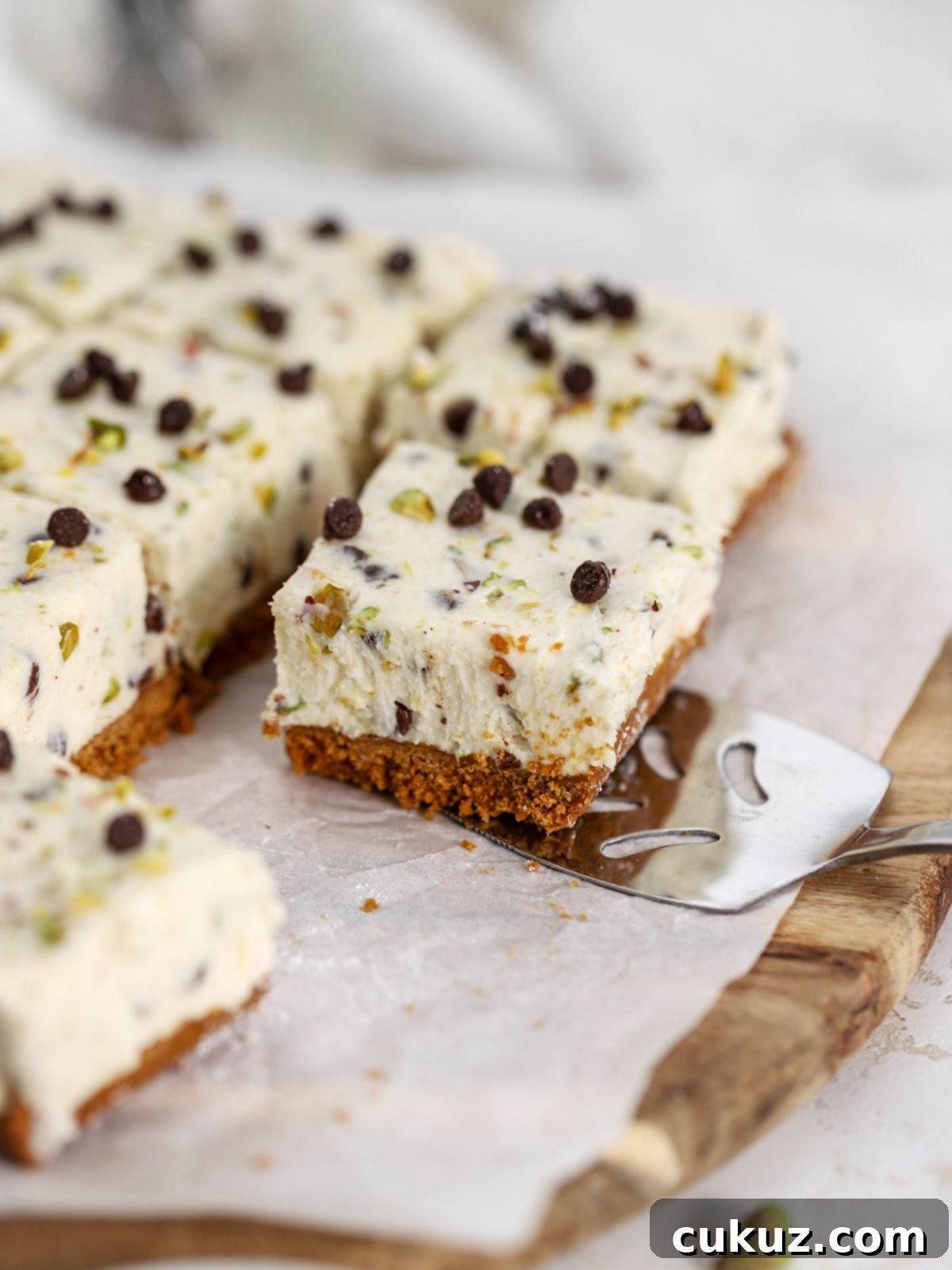 A cannoli bar topped with chocolate chips and pistachios being served.