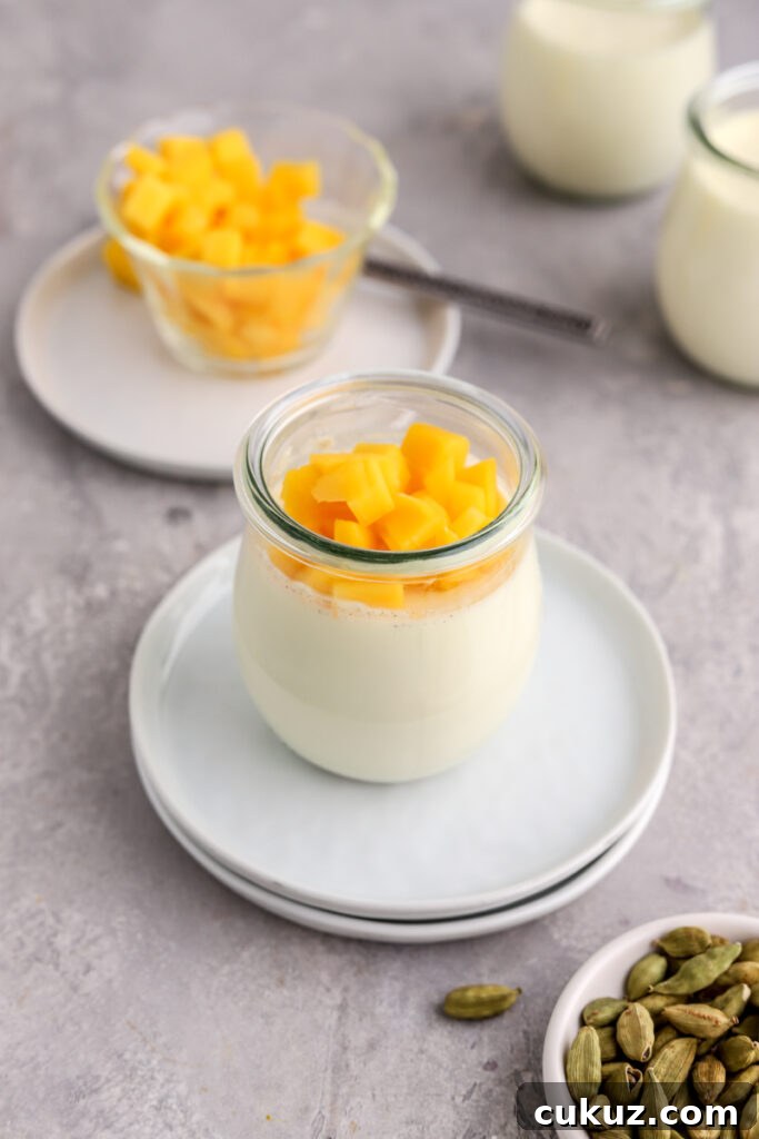 Panna cotta in jars topped with chopped mango.