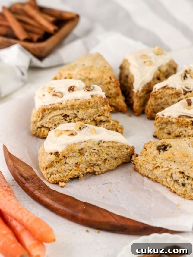 A batch of scones topped with icing and walnuts. 