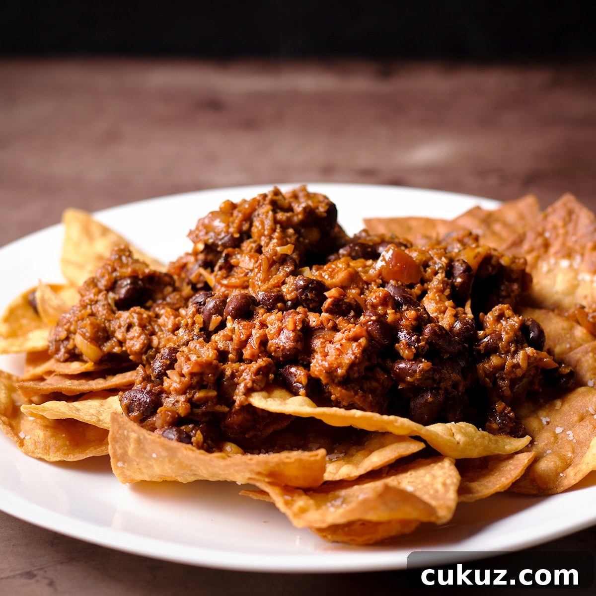 A plate of tortilla chips topped with vegan taco meat.