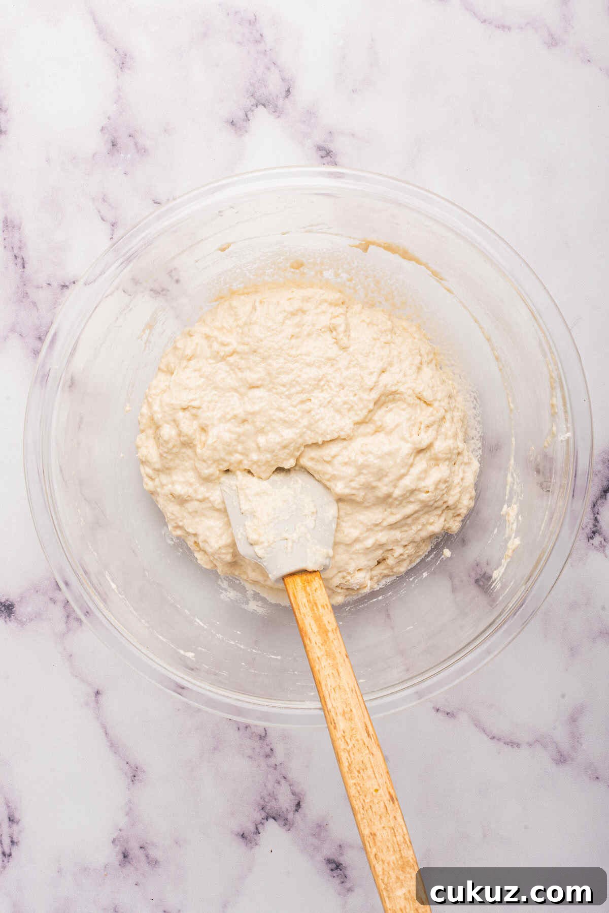 the wet ingredients added to create the bread dough in the mixing bowl.