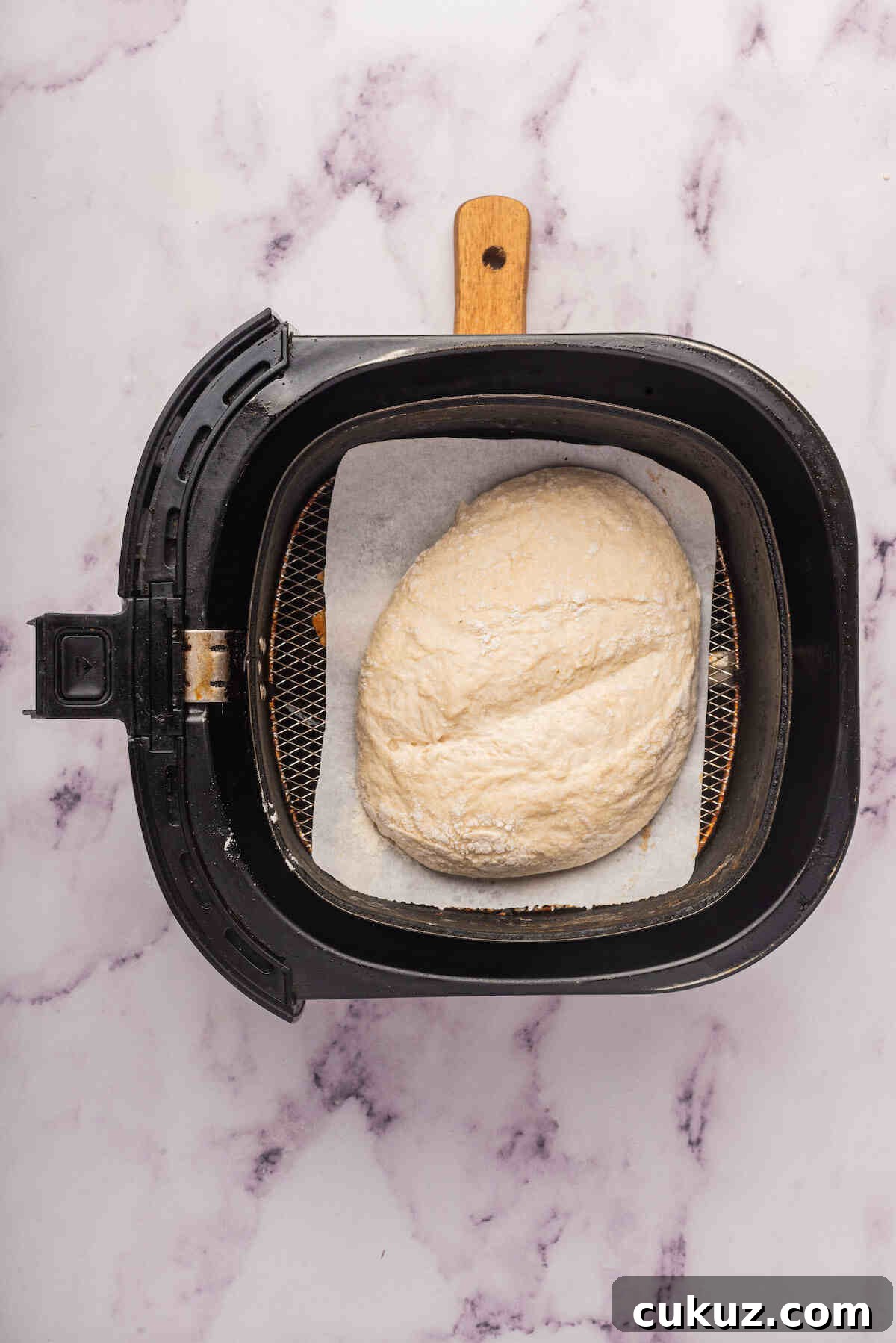 the unbaked bread inside the air fryer basket.