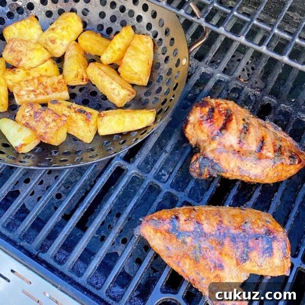 Chicken grilled on the BBQ with basket of pineapple.