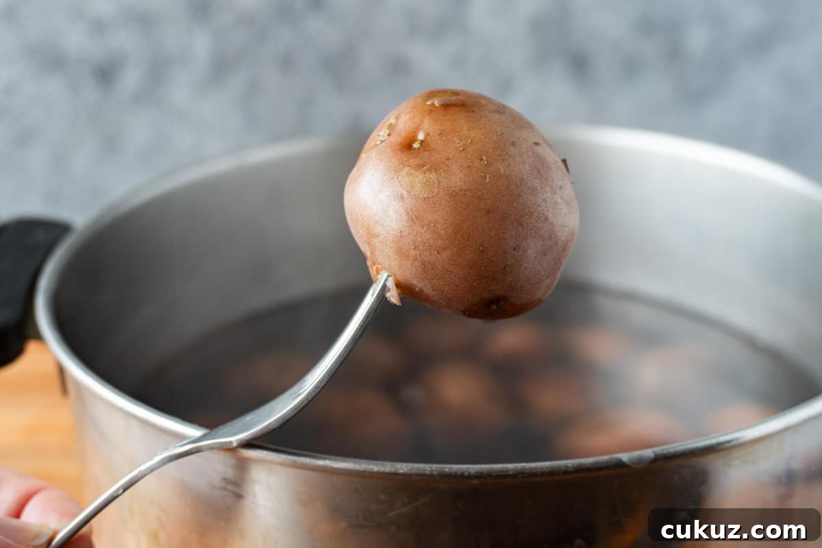 piercing a cooked potato with fork