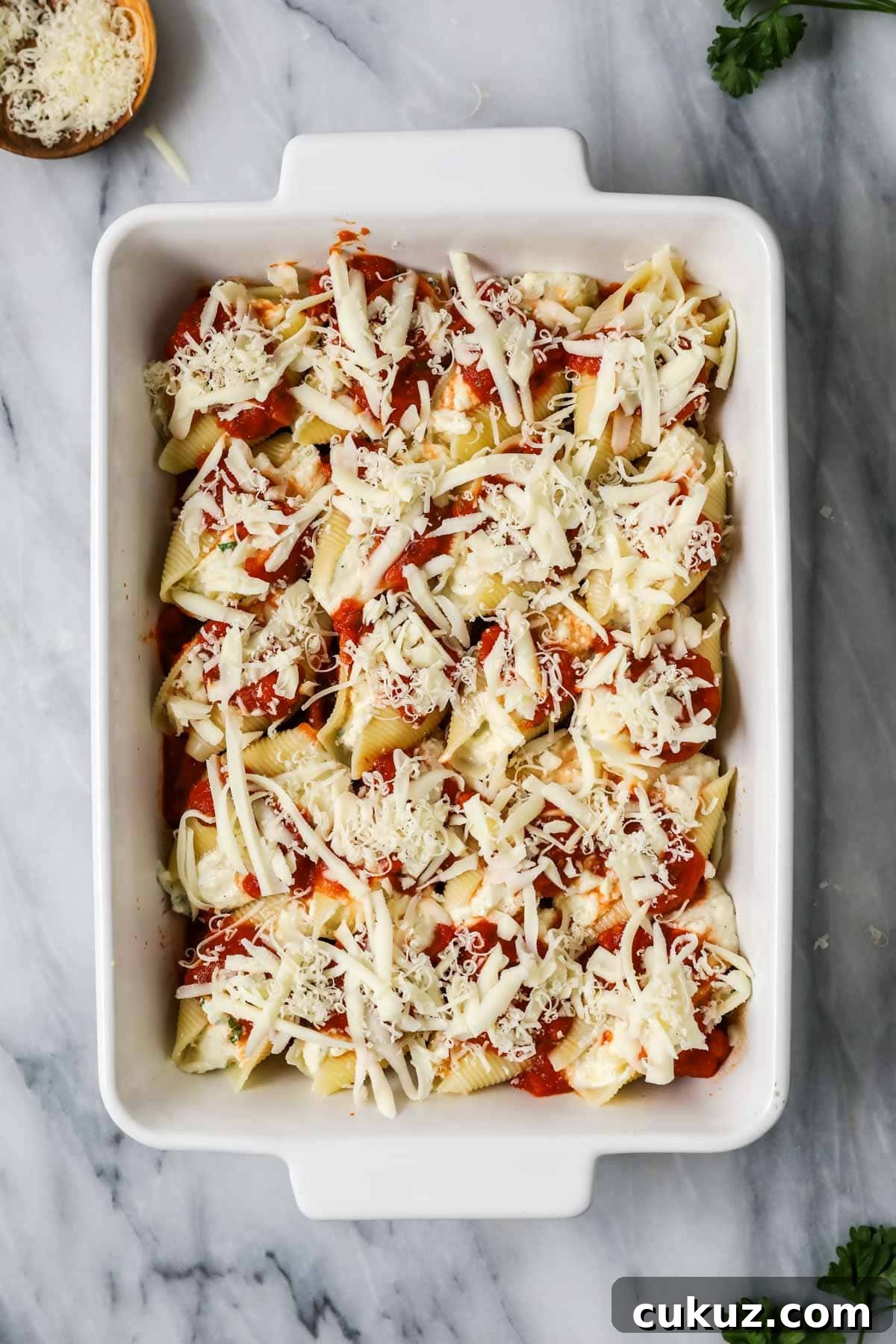 Overhead view of a pan of stuffed shells before baking.