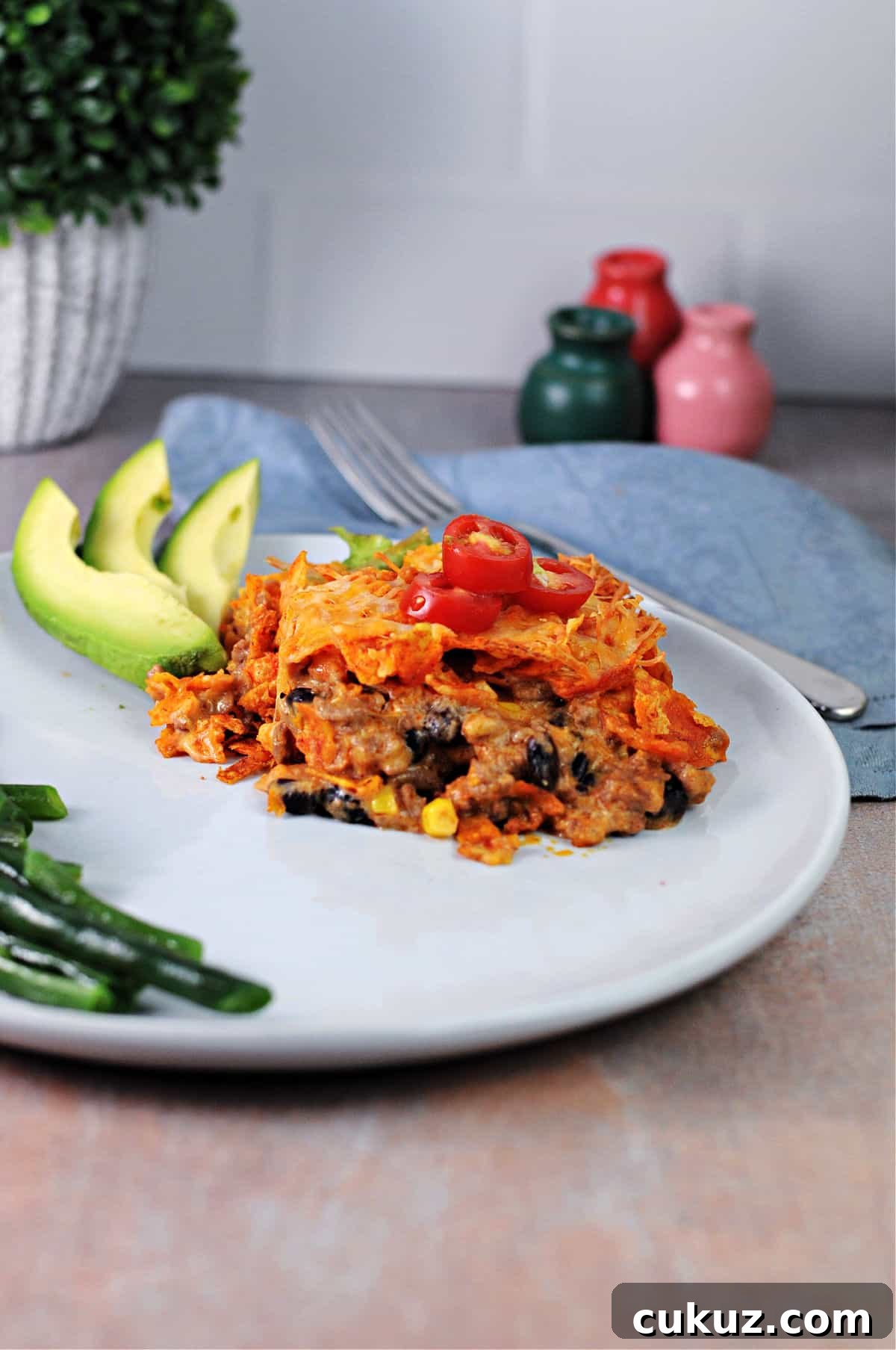 serving of dorito casserole on a plate with avocado.
