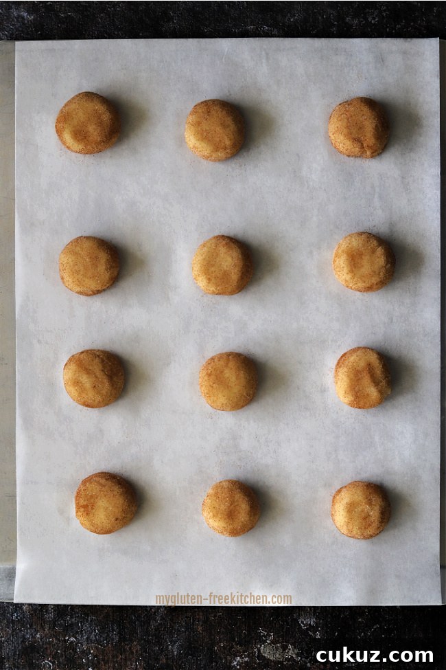 Unbaked snickerdoodles on a cookie sheet.