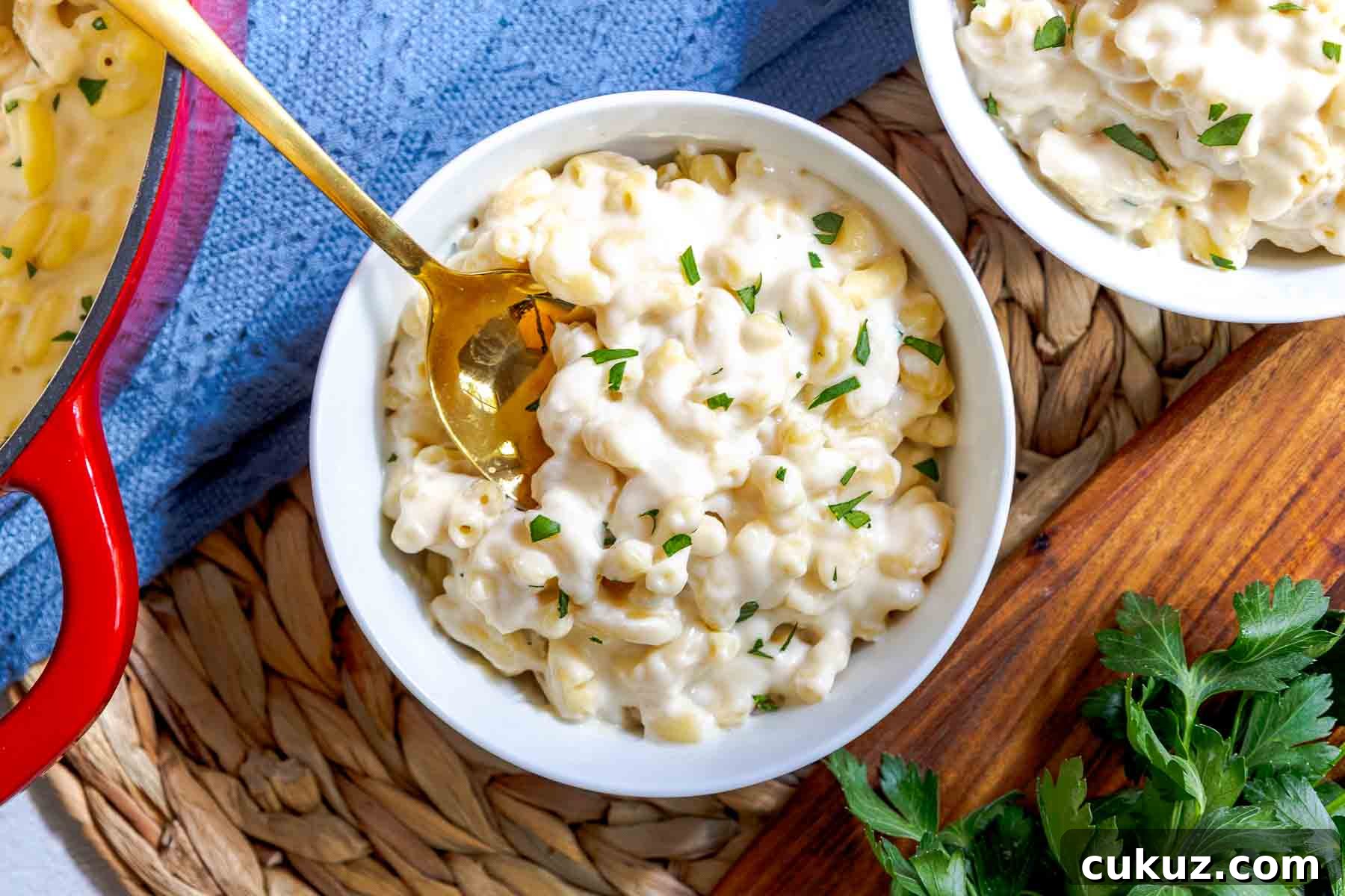 A spoon in a bowl of white cheddar mac and cheese.