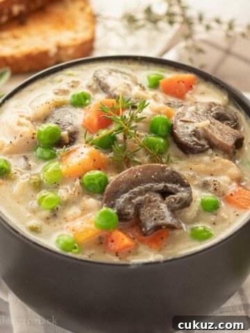 Bowl of creamy chicken wild rice soup with herbs.