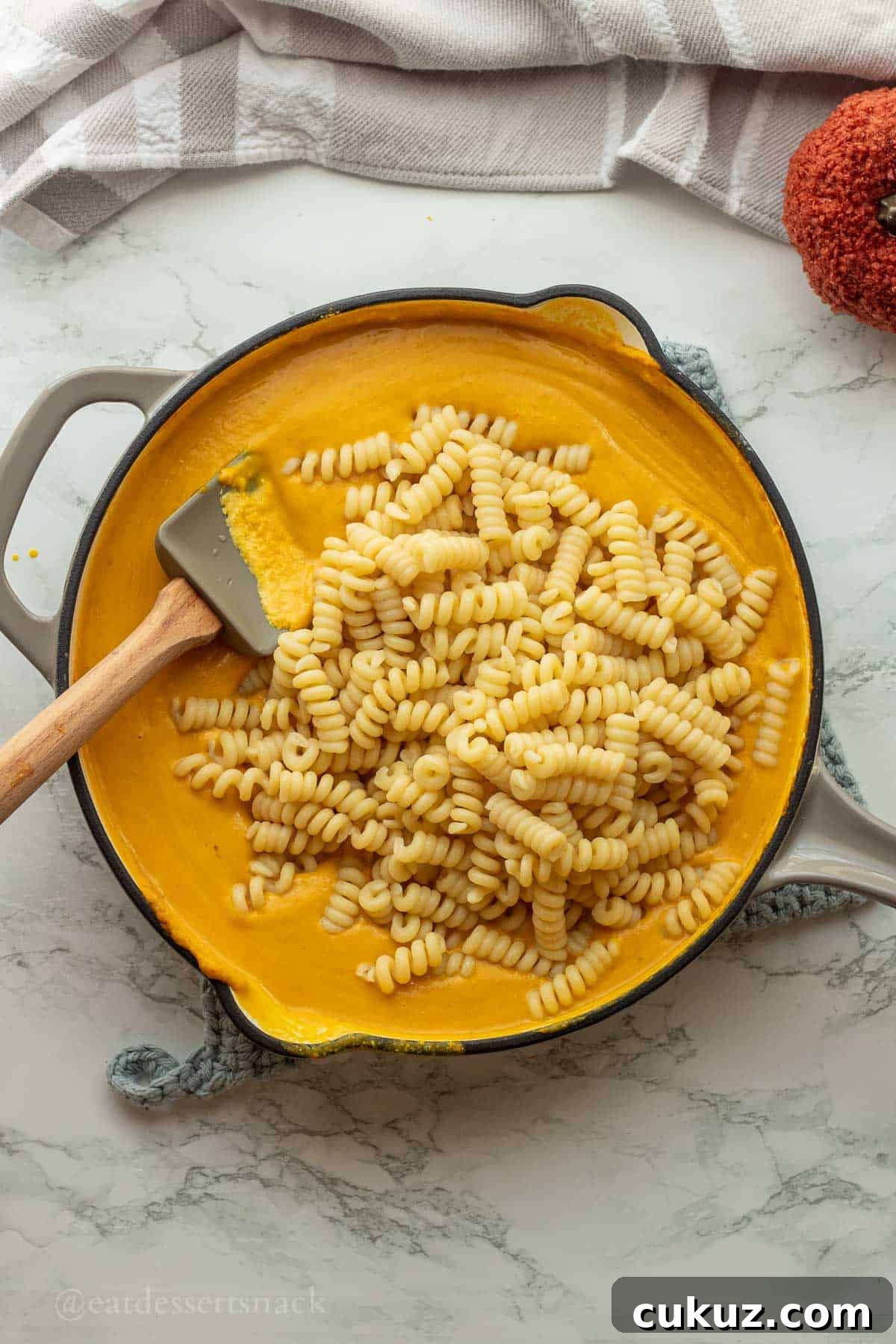 Cooked pasta in pan with pumpkin sauce.