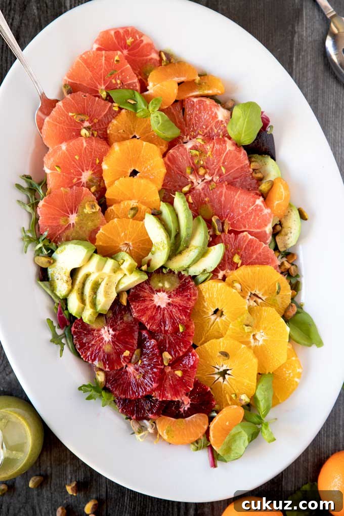 A platter filled with citrus fruits on a bed of salad greens.