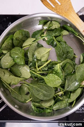 Sauteing spinach in a pan.