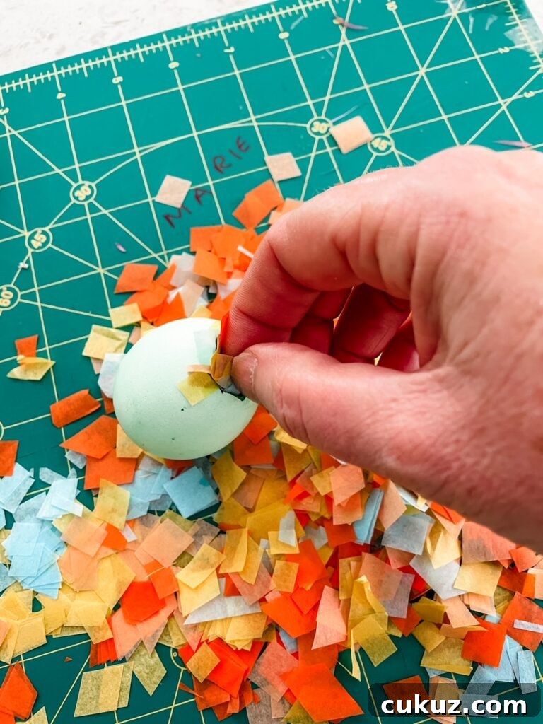 The confetti pieces being placed in the egg shell
