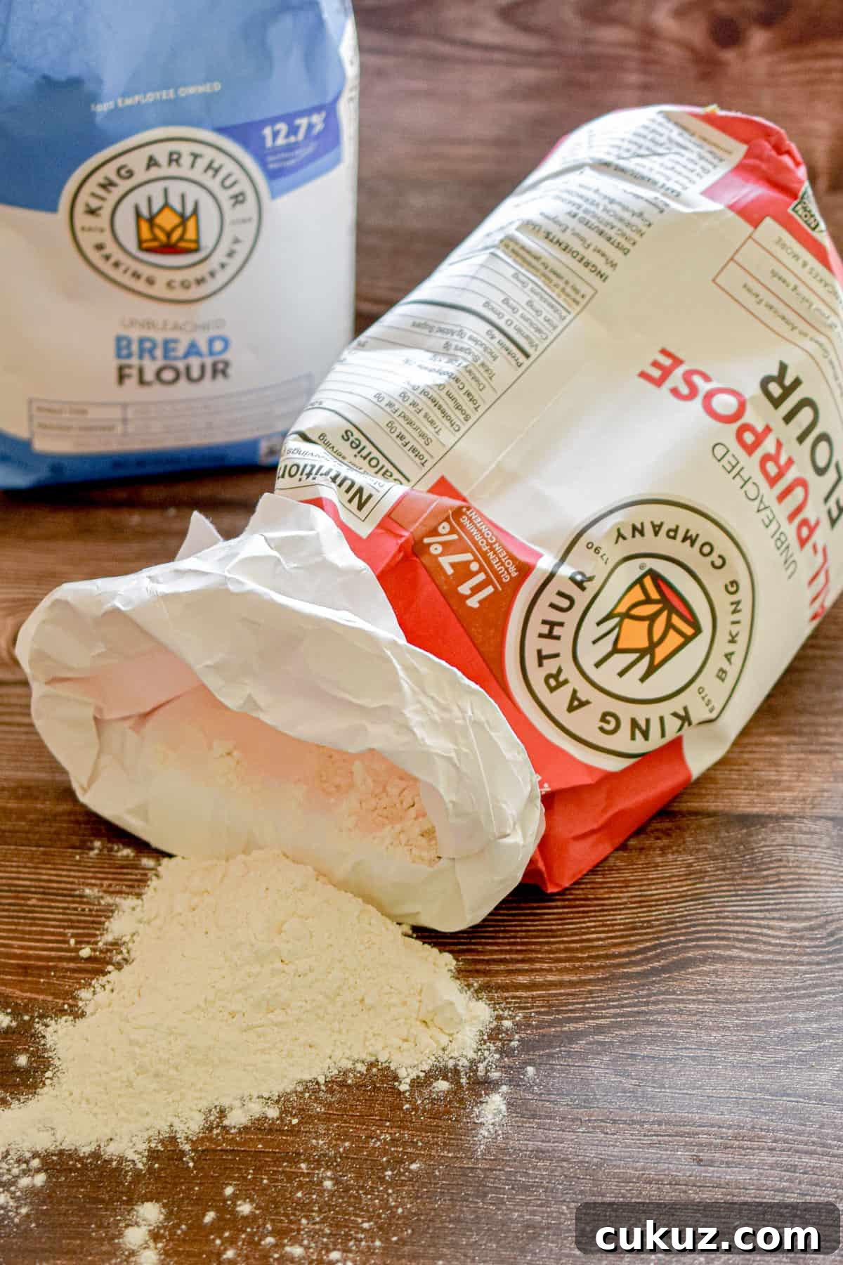 Bread Flour vs. All-Purpose Flour: Key Differences You Should Know 2 Bread flour vs all purpose flour bags are on a wooden background.