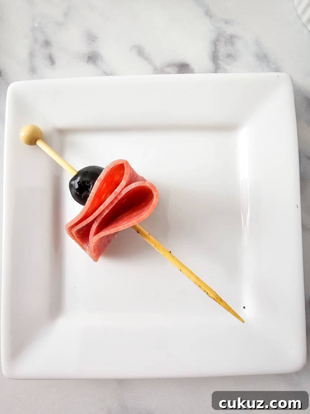 olive and salami on a skewer