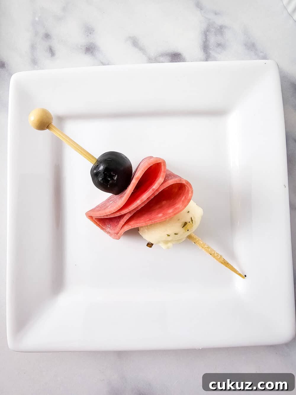 olive, salami, and mozzarella ball on a skewer