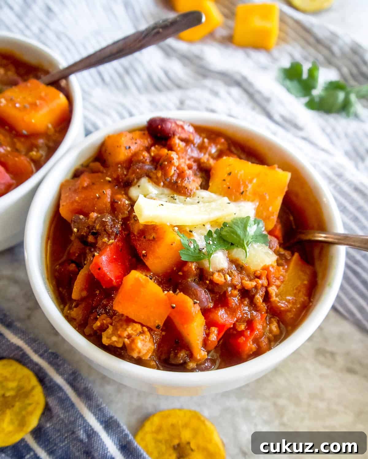 Turkey black bean butternut squash chili in a bowl with a spoon.