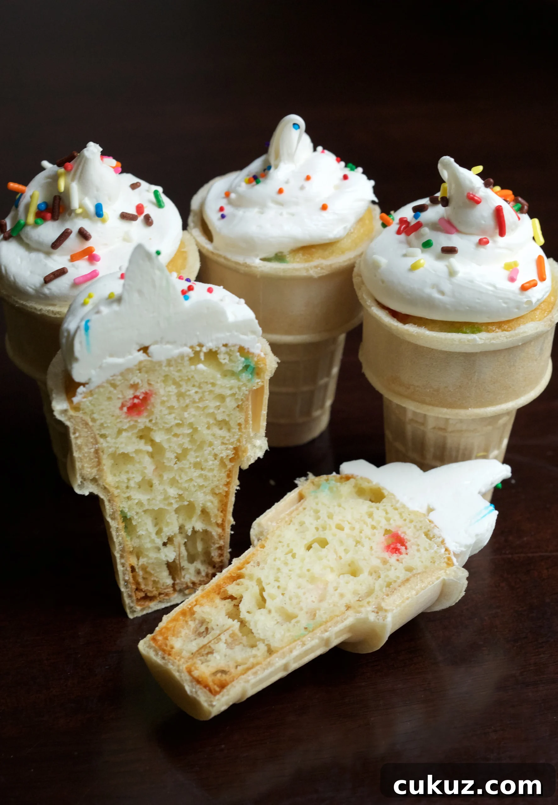 Ice Cream Cone Cupcakes on a black background. One cone has been cut open to show the cupcake inside.