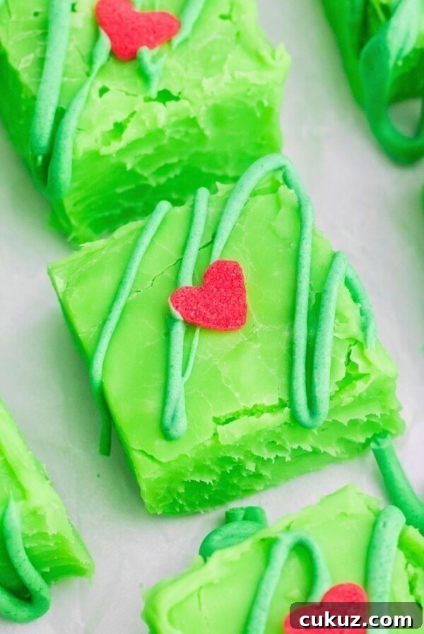 Bright green squares of fudge cut on a white table.